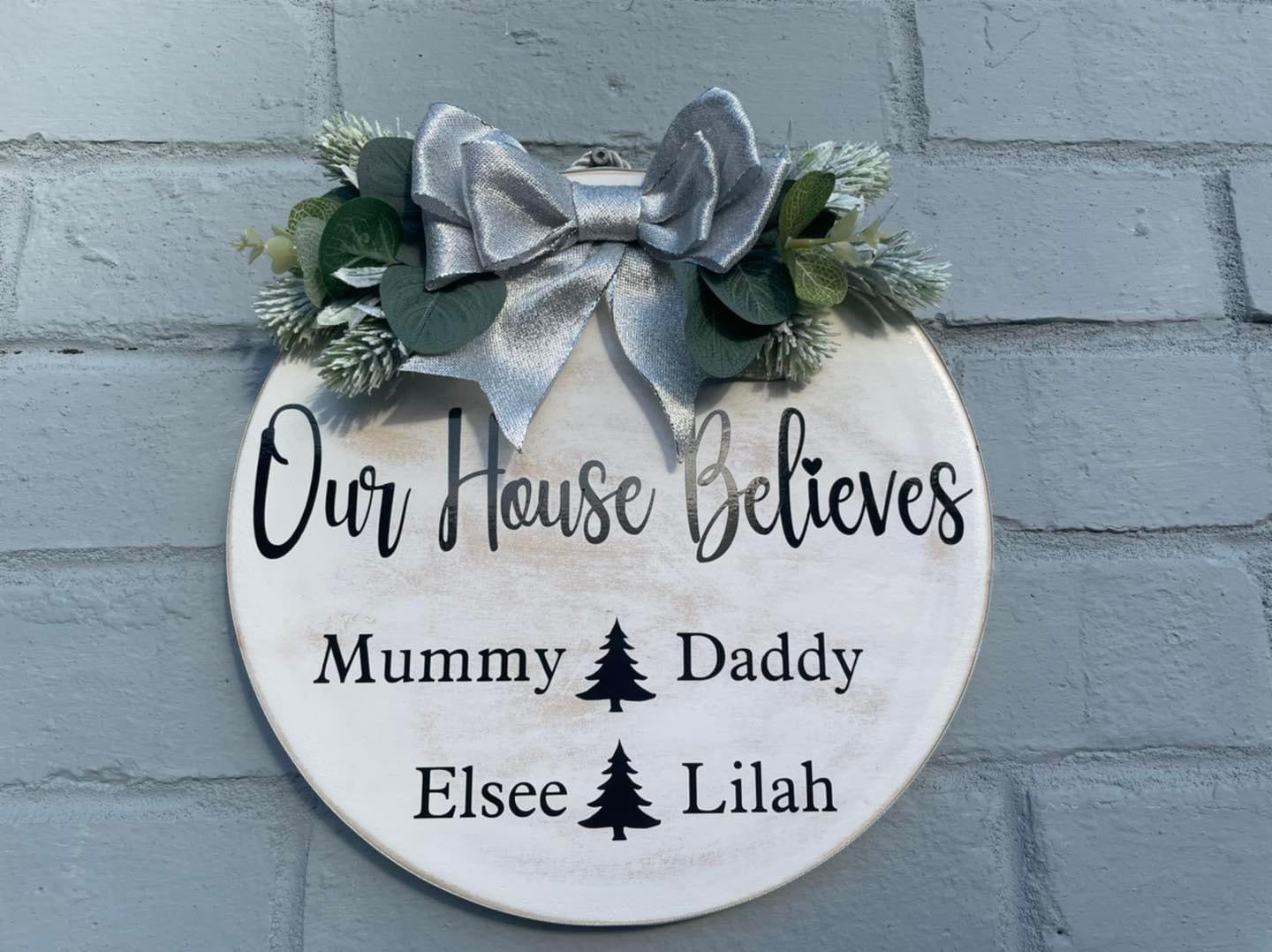 Personalised “our house believes” plaque with bow and faux foliage, Christmas