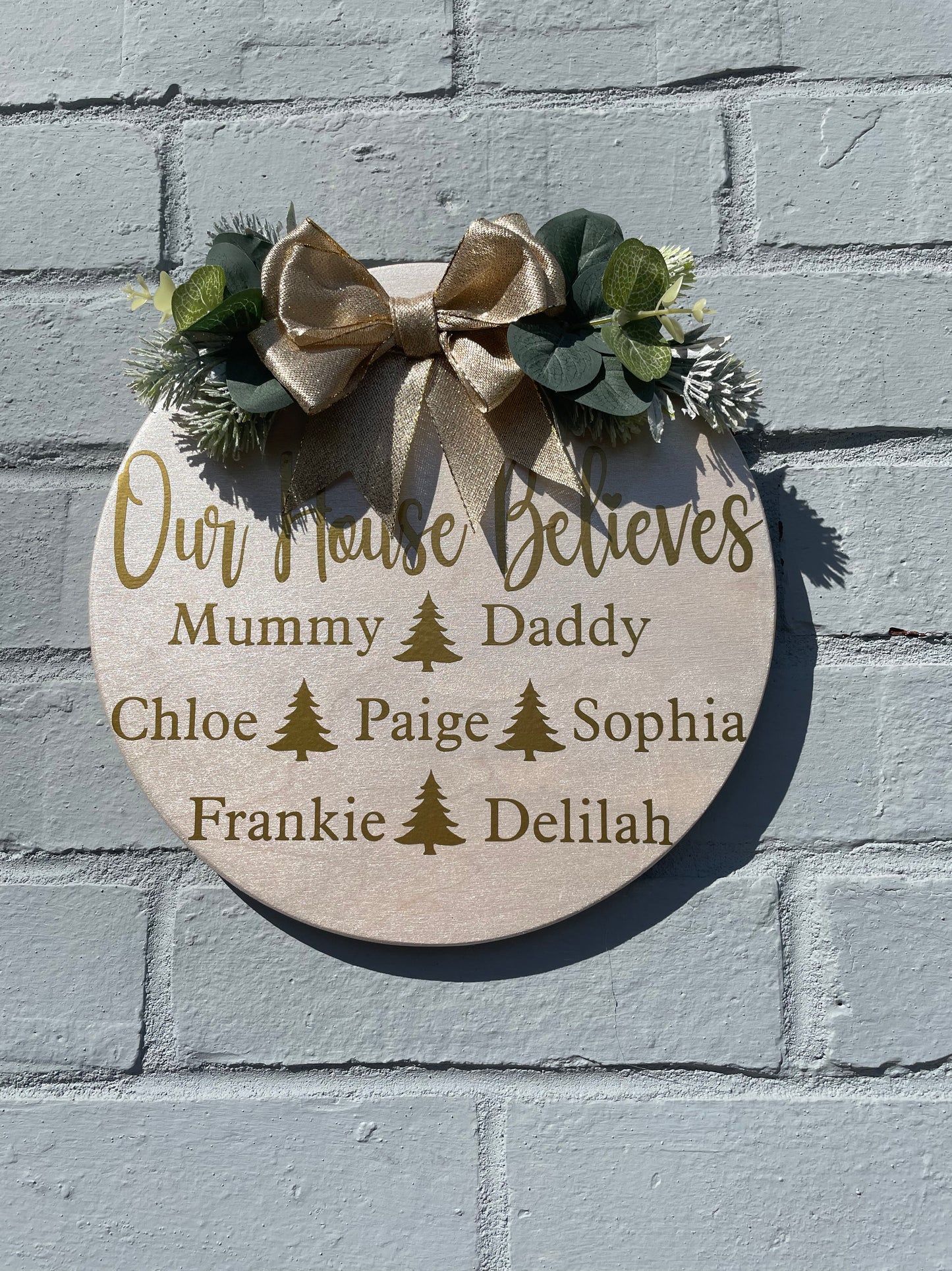 Personalised “our house believes” plaque with bow and faux foliage, Christmas