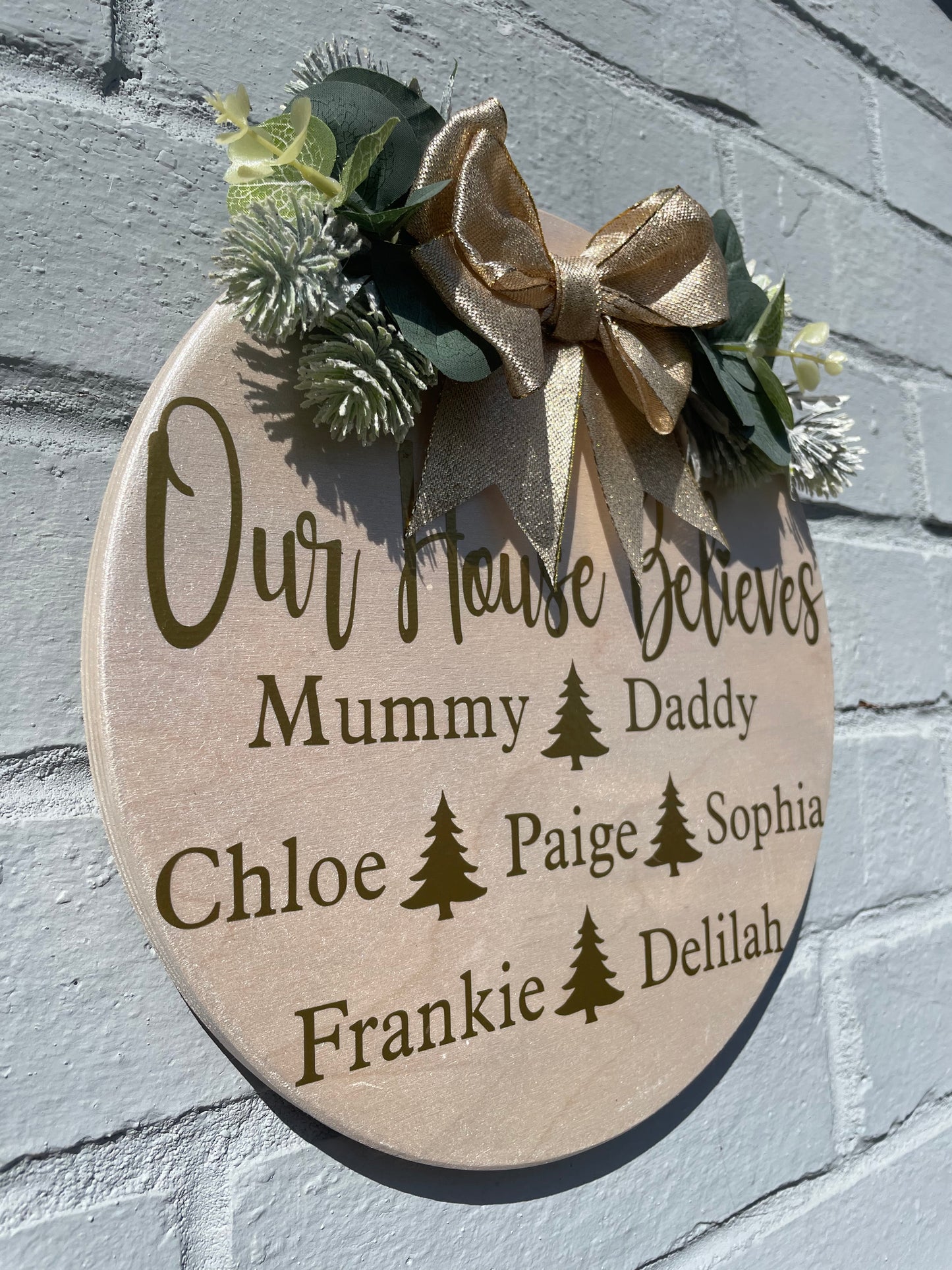 Personalised “our house believes” plaque with bow and faux foliage, Christmas