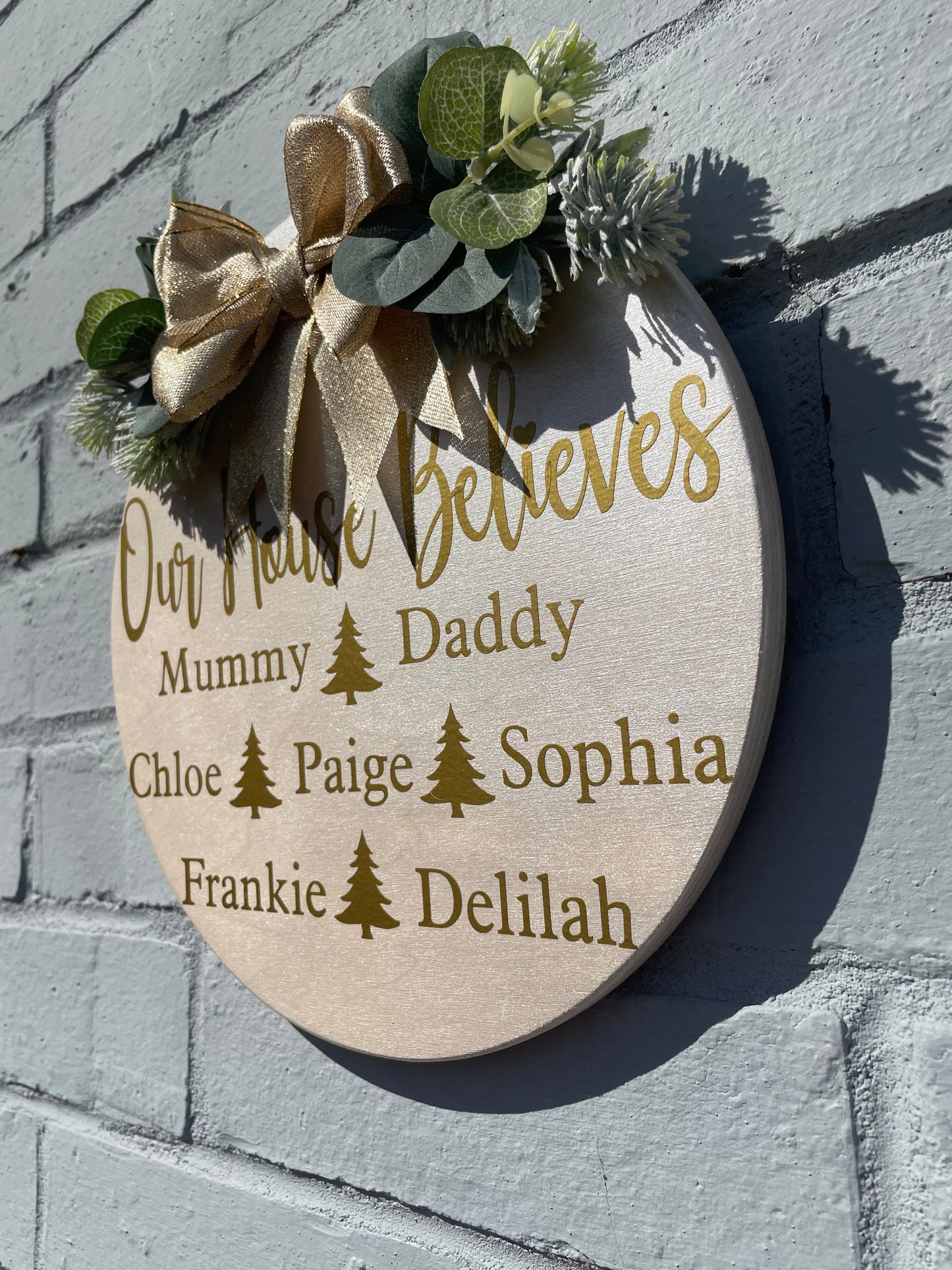 Personalised “our house believes” plaque with bow and faux foliage, Christmas