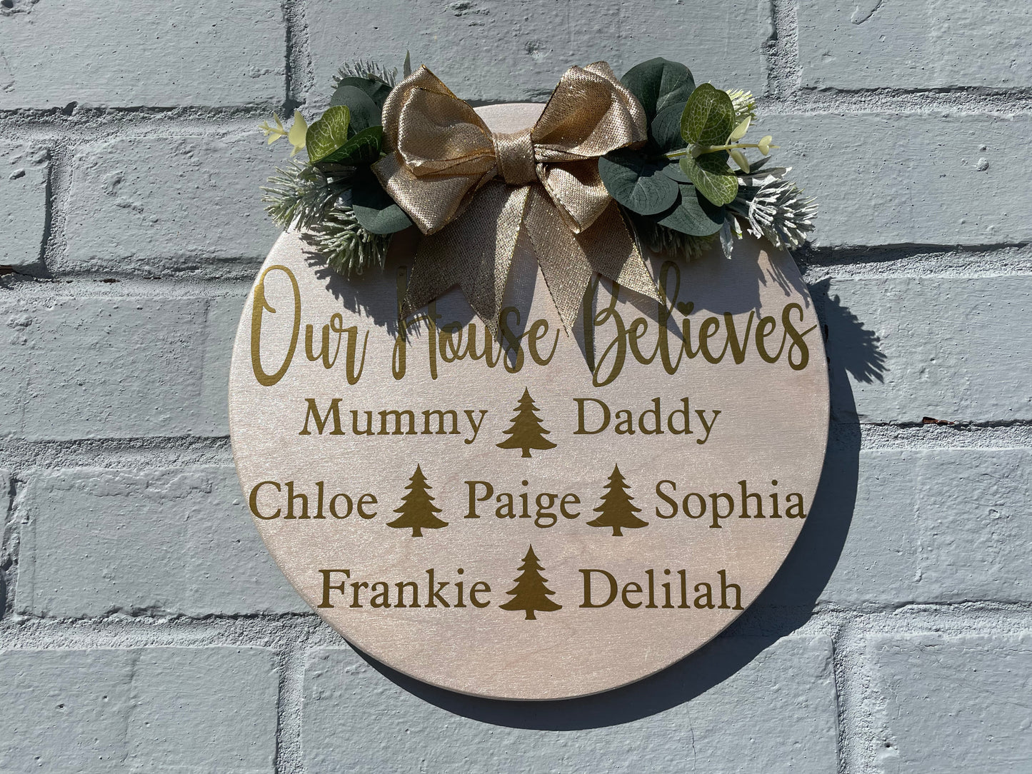 Personalised “our house believes” plaque with bow and faux foliage, Christmas